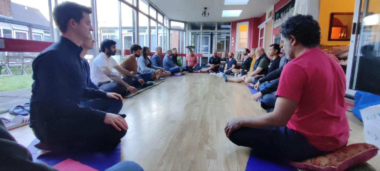 A men's circle seated together during a practice session