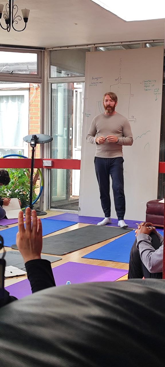 Kieran Dowling teaching a group in front of a whiteboard